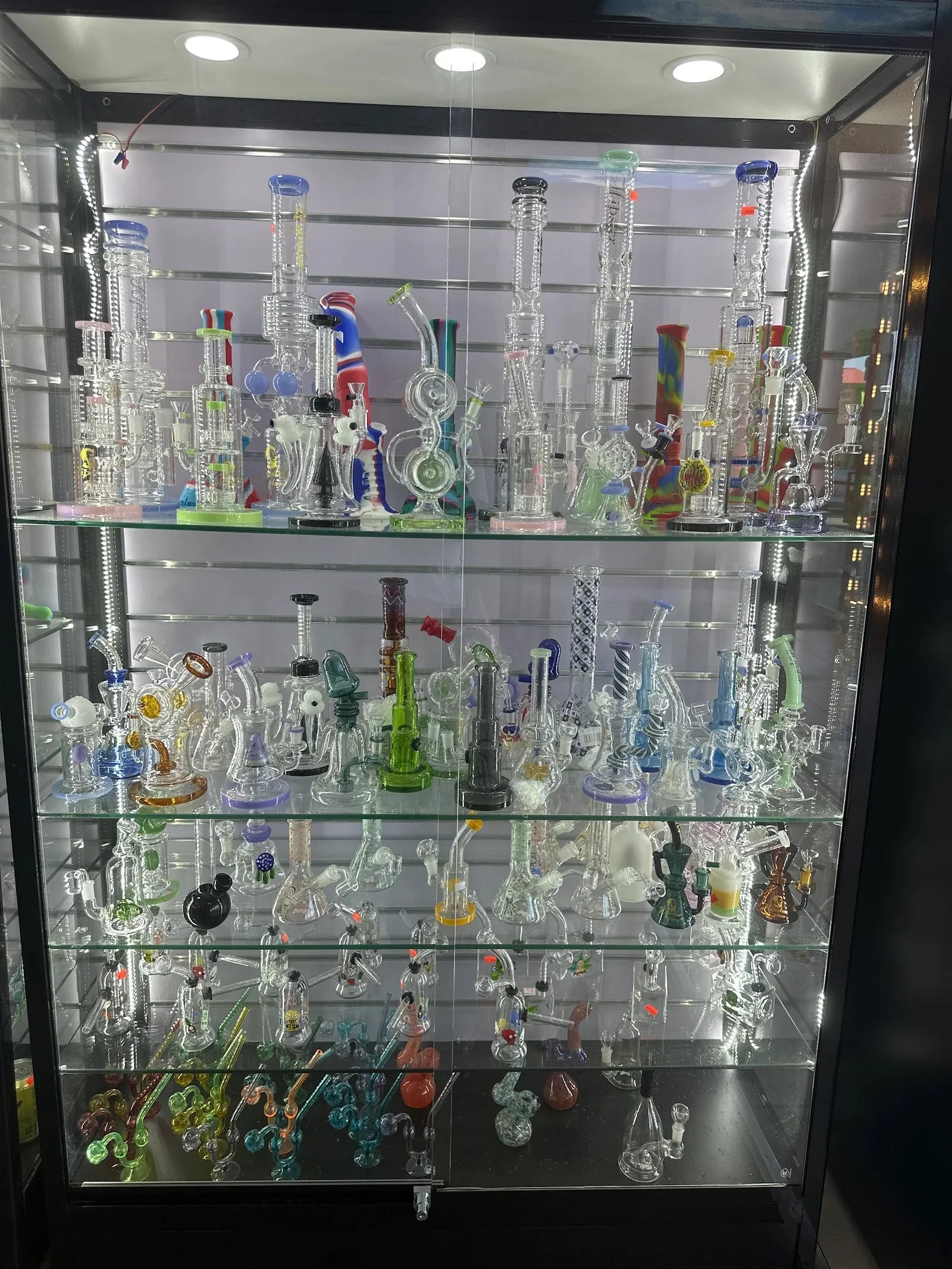 Water pipes and glass on the lit shelves inside White Cloud 2 Smoke Shop